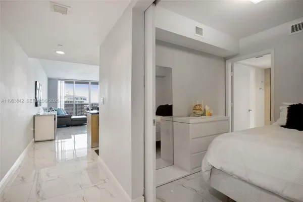 a bedroom with a bed and a view of kitchen