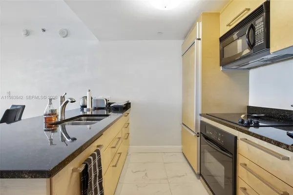 a kitchen with stainless steel appliances granite countertop a sink stove and cabinets