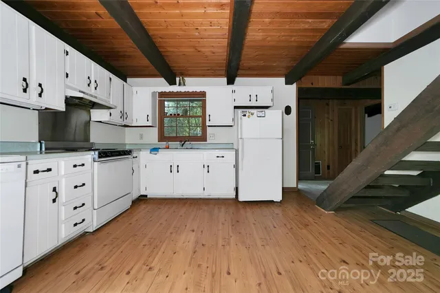 a kitchen with cabinets appliances a sink and a counter space