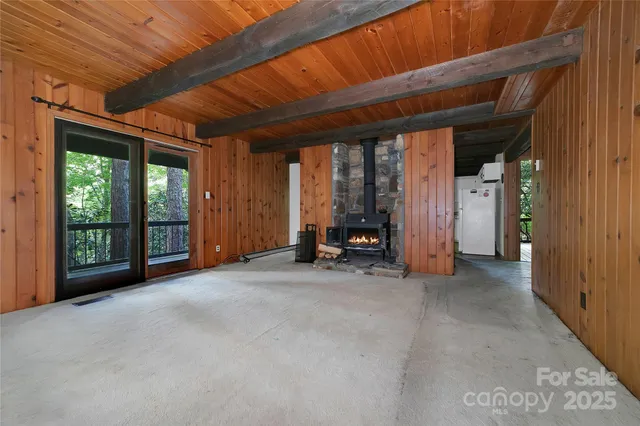 a view of an empty room with wooden floor and walls