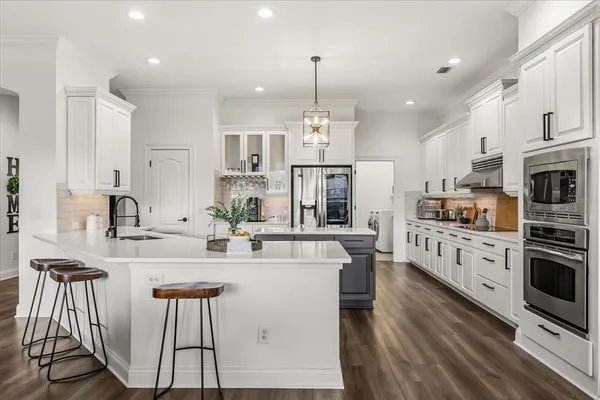 a kitchen with kitchen island granite countertop a sink stainless steel appliances and cabinets