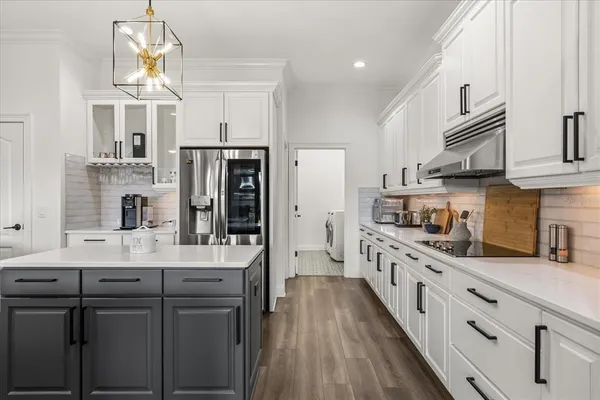 a kitchen with stainless steel appliances granite countertop a stove a sink and white cabinets