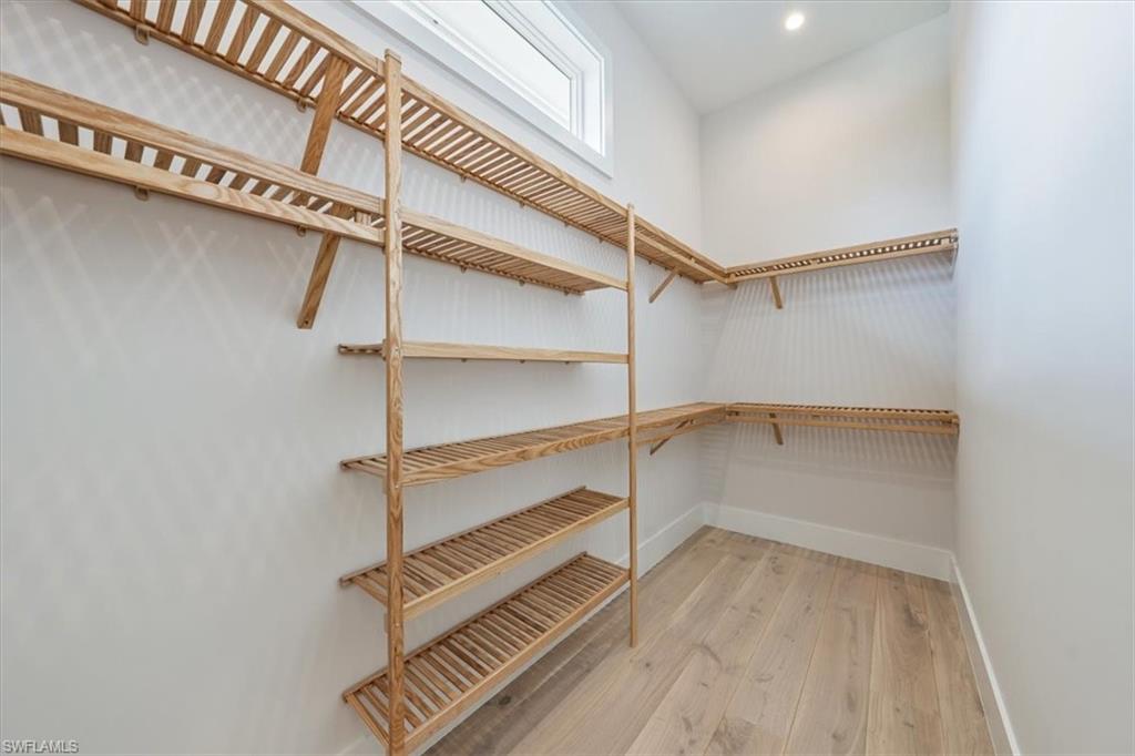 23517 Coconut Road Estero, FL 34134 - Photo 20 of 40 One of two primary bedroom closets. All closets are complete with natural grain Copewood closet systems.