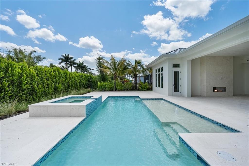 23517 Coconut Road Estero, FL 34134 - Photo 36 of 40 The heated salt swimming pool with raised in-ground spa and sun shelf set the stage for fun in the sun!