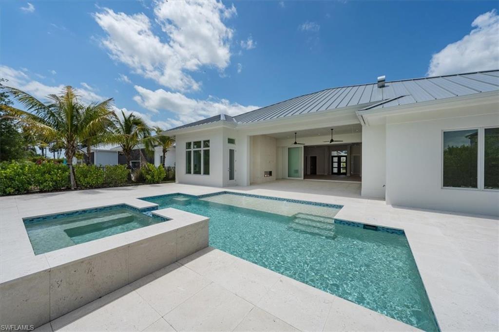 23517 Coconut Road Estero, FL 34134 - Photo 37 of 40 The heated salt swimming pool with raised in-ground spa and sun shelf set the stage for fun in the sun!