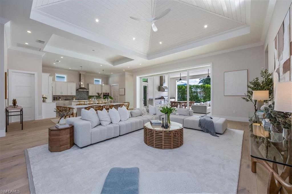 23517 Coconut Road Estero, FL 34134 - Photo 4 of 40 The open concept main living area features a vaulted ceiling with nickel gap and beam work, 10' impact pocket sliders, and Sub-Zero/Wolf kitchen appliance suite