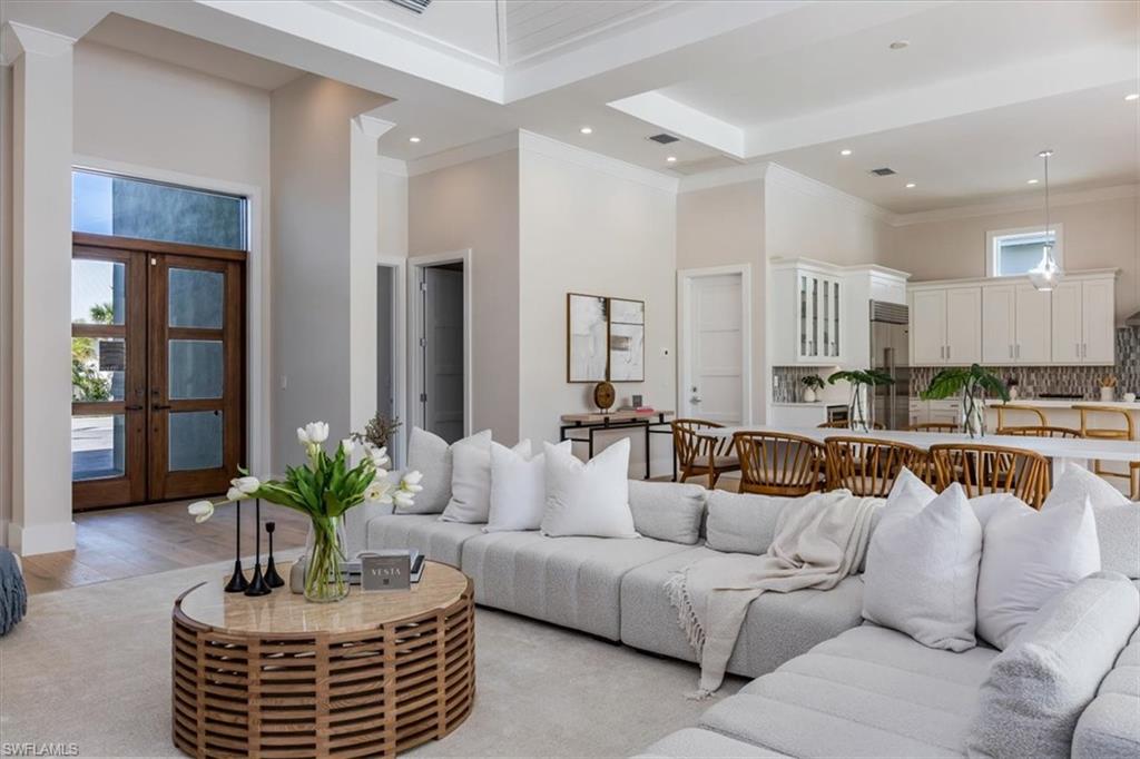 23517 Coconut Road Estero, FL 34134 - Photo 5 of 40 The open concept main living area features a vaulted ceiling with nickel gap and beam work, 10' impact pocket sliders, and Sub-Zero/Wolf kitchen appliance suite