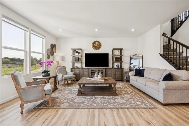 a living room with furniture wooden floor and a flat screen tv