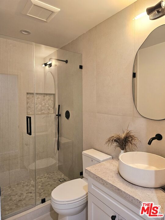 17 Sunset Avenue, Unit 1 Venice, CA 90291 - Photo 18 of 30 a bathroom with a granite countertop sink mirror a toilet and shower