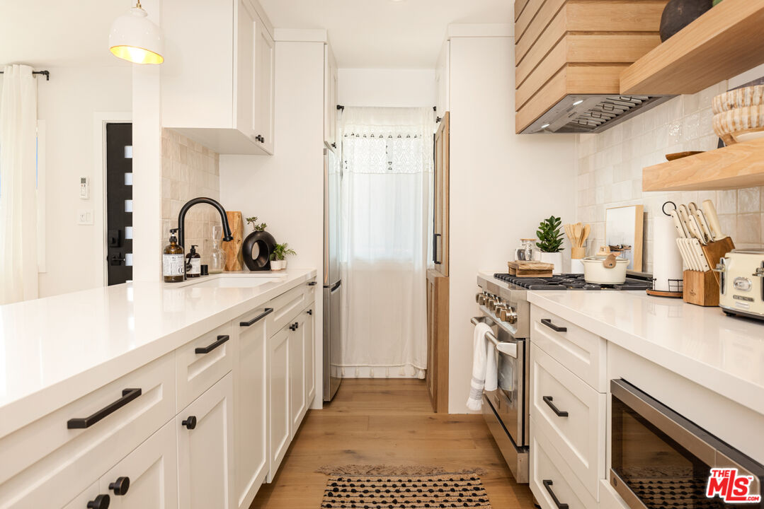 17 Sunset Avenue, Unit 1 Venice, CA 90291 - Photo 7 of 30 a kitchen with stainless steel appliances a sink stove refrigerator and cabinets