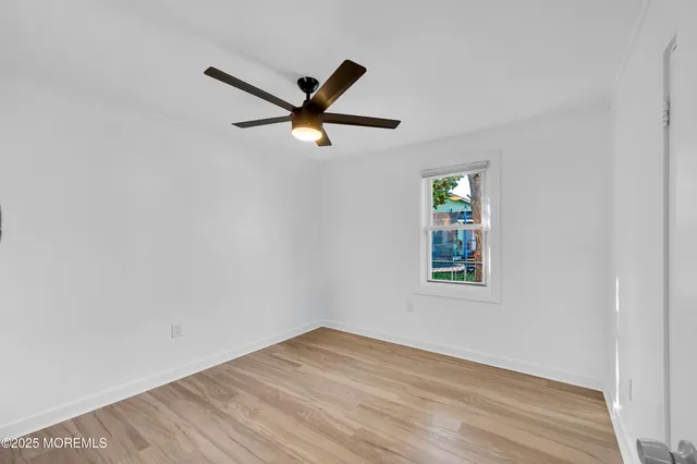 an empty room with a window and a fan