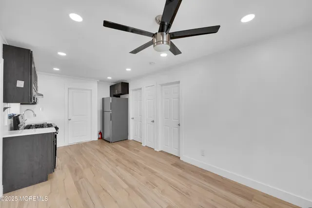 a room with a ceiling fan and a wooden floor