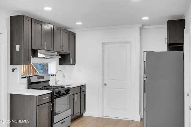 a kitchen with stainless steel appliances granite countertop a stove a refrigerator and a sink