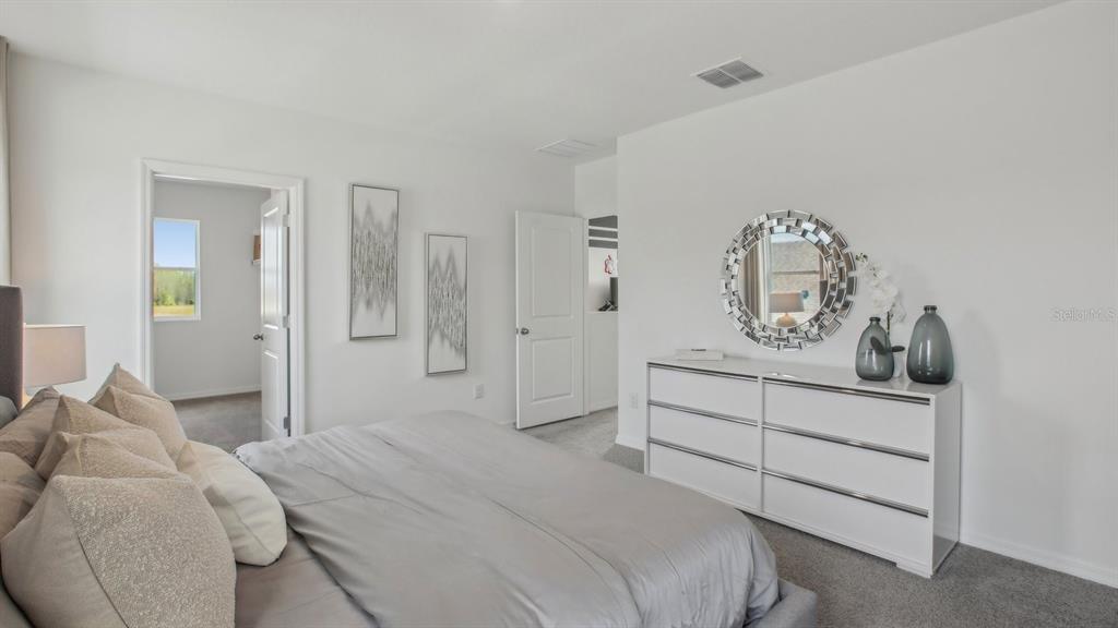 38370 Tea Rose Avenue Zephyrhills, FL 33540 - Photo 27 of 36 a bedroom with a bed and painting on the wall