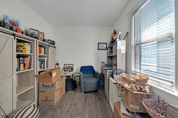 a living room with furniture a window and wooden floor