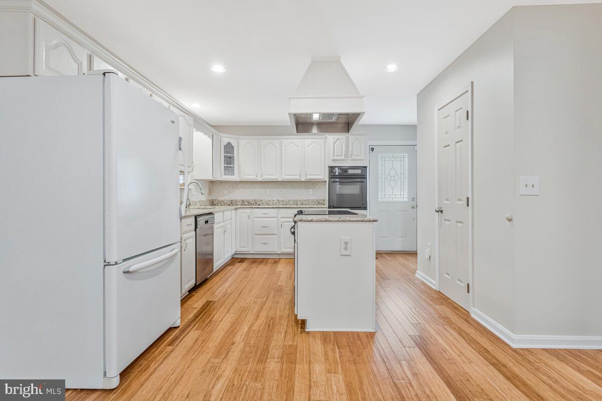 11423 Rawhide Road Lusby, MD 20657 - Photo 11 of 37 a kitchen with white cabinets and stainless steel appliances