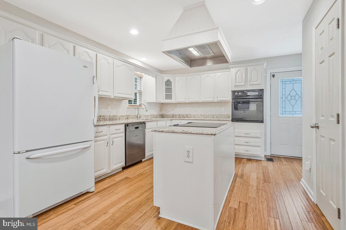 11423 Rawhide Road Lusby, MD 20657 - Photo 12 of 37 a kitchen with white cabinets and white appliances
