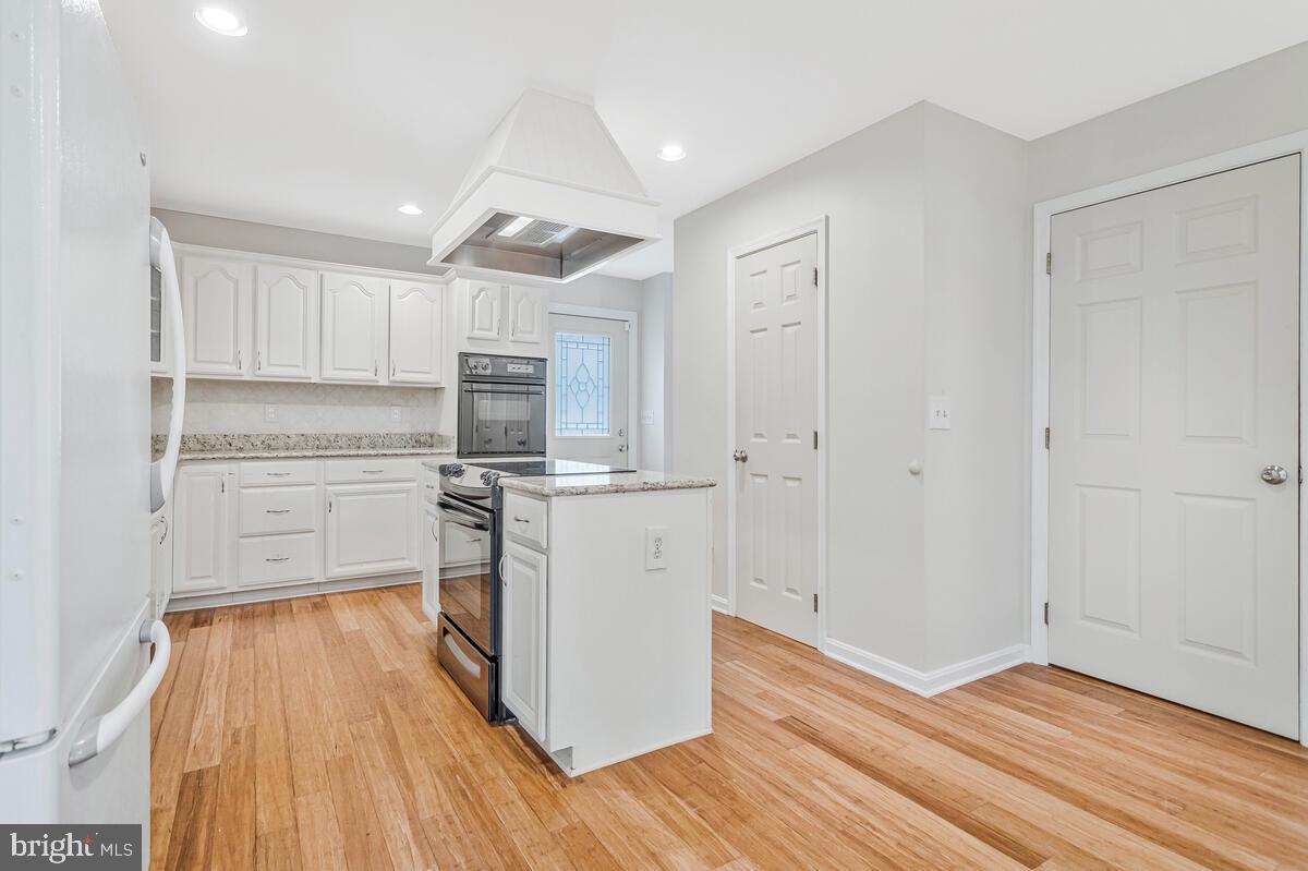 11423 Rawhide Road Lusby, MD 20657 - Photo 15 of 37 a kitchen with wooden floors and white appliances