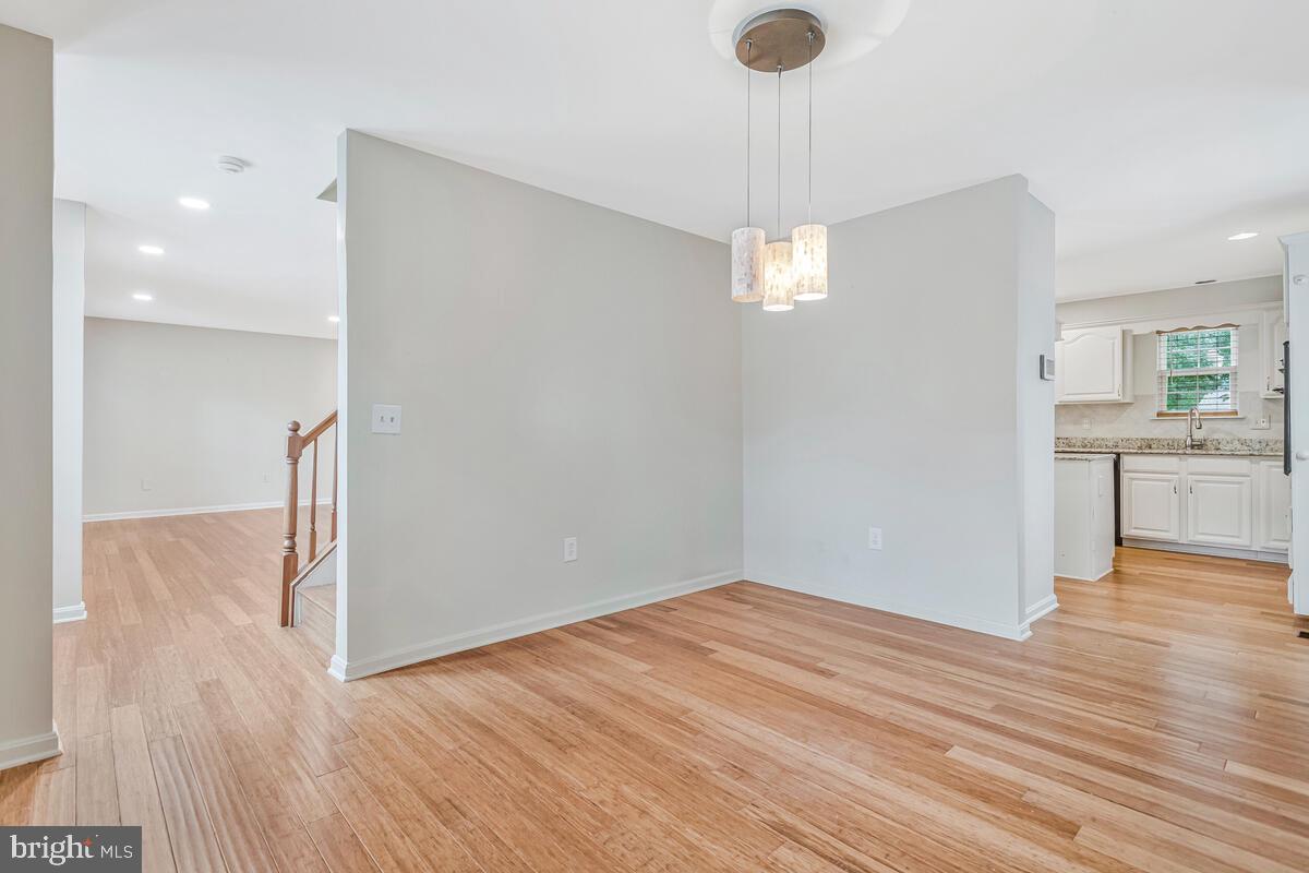 11423 Rawhide Road Lusby, MD 20657 - Photo 17 of 37 a view of empty room with wooden floor and kitchen view
