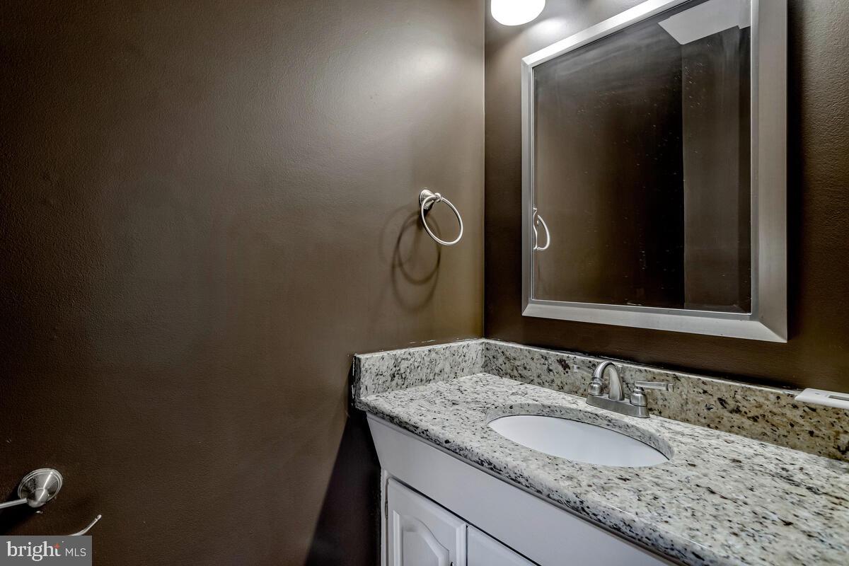 11423 Rawhide Road Lusby, MD 20657 - Photo 18 of 37 a bathroom with a granite countertop sink and a mirror