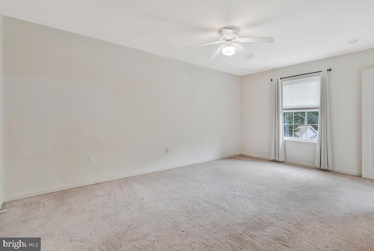 11423 Rawhide Road Lusby, MD 20657 - Photo 19 of 37 a view of an empty room with a ceiling fan and a window