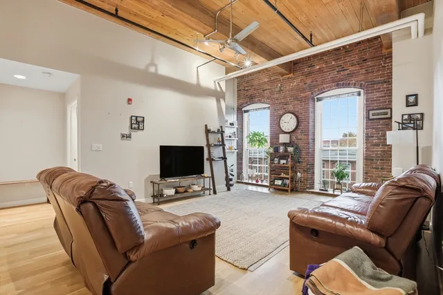 a living room with furniture a large window and a flat screen tv