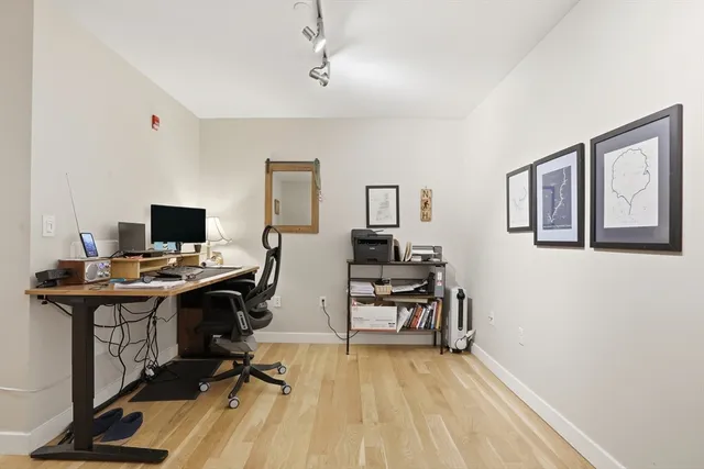 a view of a workspace with furniture and a window