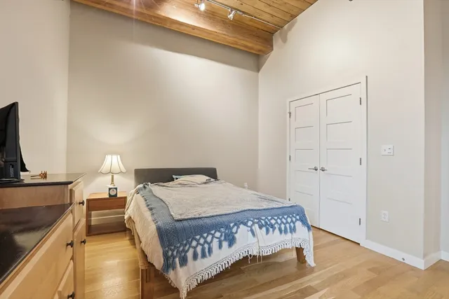 a bedroom with a bed and a flat tv screen on a dresser
