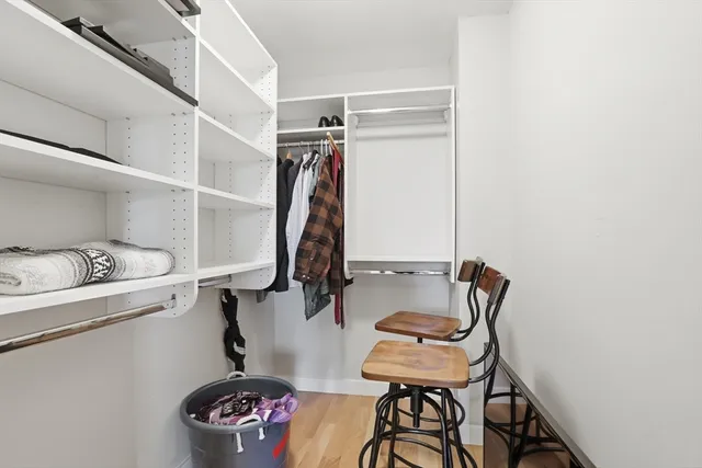 a view of walk in closet with clothes and shoes