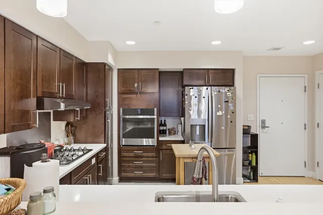 a kitchen with stainless steel appliances kitchen island granite countertop a refrigerator and a stove