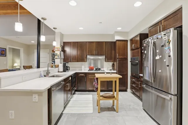a kitchen with stainless steel appliances granite countertop a refrigerator and a stove top oven