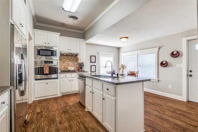 a kitchen with cabinets and wooden floor