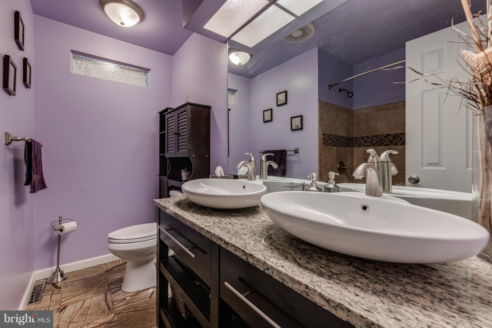 1519 National Road Baltimore, MD 21237 - Photo 12 of 30 a bathroom with a granite countertop sink a toilet a mirror and vanity