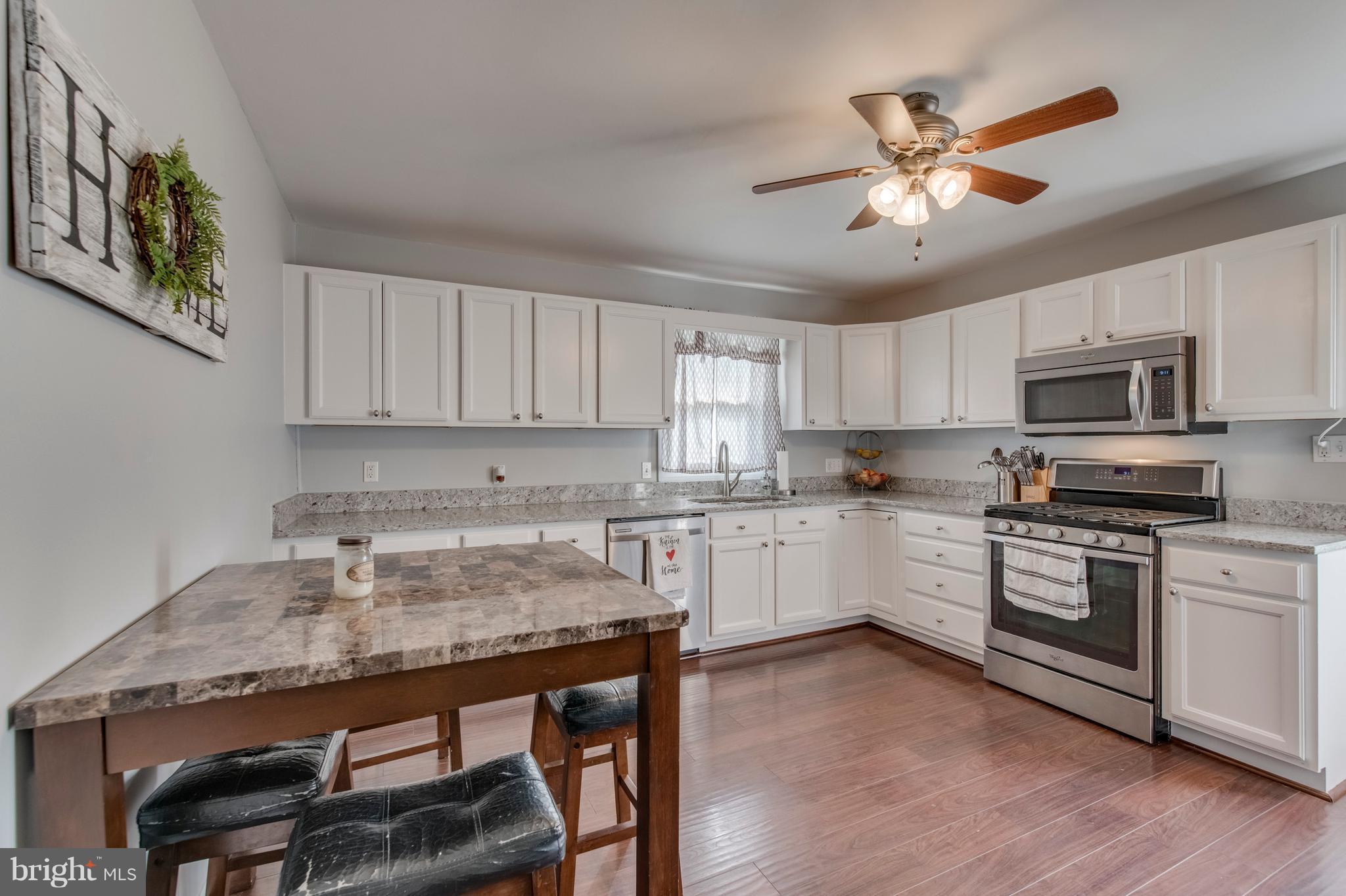 1519 National Road Baltimore, MD 21237 - Photo 6 of 30 a kitchen with a table chairs microwave and cabinets
