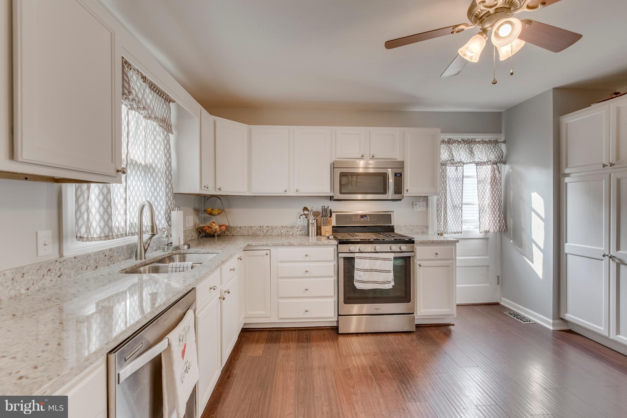1519 National Road Baltimore, MD 21237 - Photo 7 of 30 a kitchen with stainless steel appliances granite countertop a refrigerator a stove top oven a sink and dishwasher with wooden floor