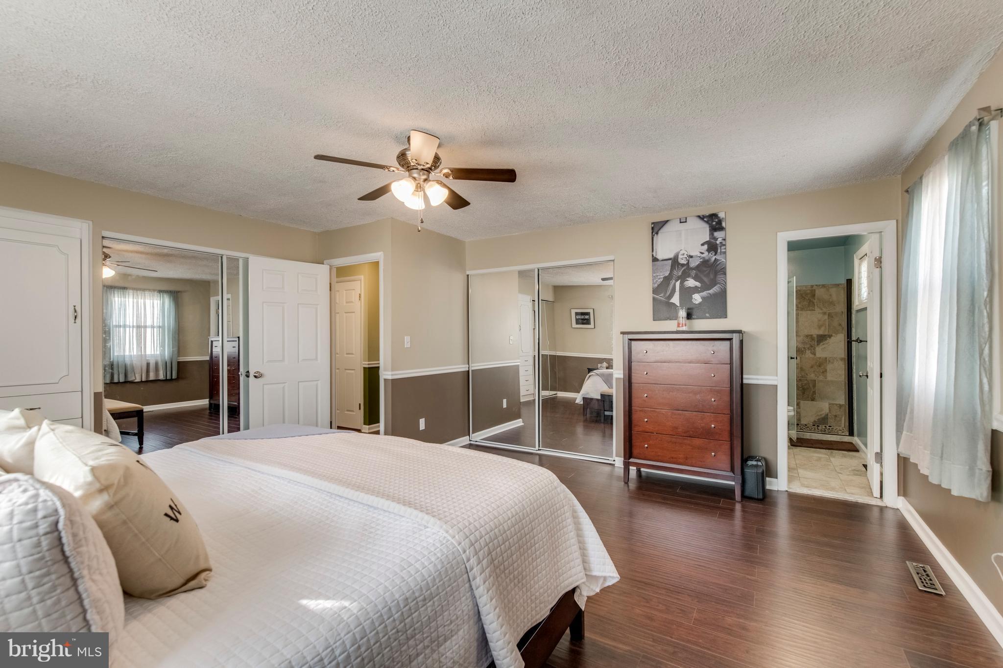 1519 National Road Baltimore, MD 21237 - Photo 9 of 30 a spacious bedroom with a bed and a chandelier