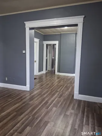 a view of a hallway with wooden floor and a door