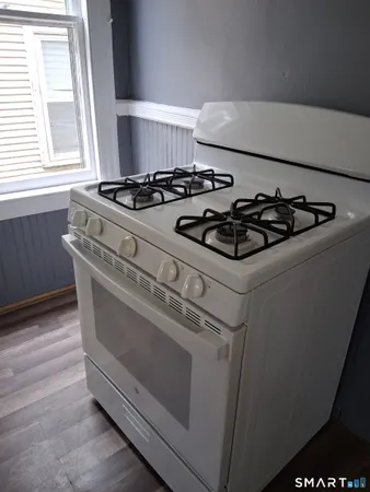 a white stove top oven sitting inside of a kitchen