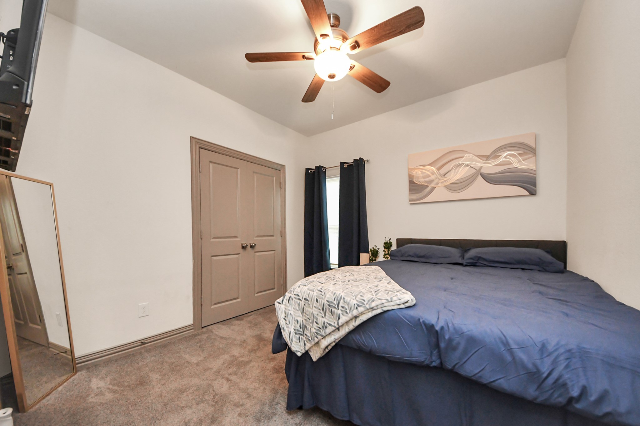 5334 Pershing Street Houston, TX 77033 - Photo 20 of 43 a bedroom with a large bed and a chandelier