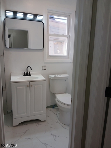 14 Ruth Street Irvington, NJ 07111 - Photo 9 of 15 a bathroom with a toilet a sink a window and mirror