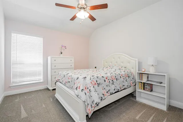 a bed sitting in a bedroom next to a window and a chandelier