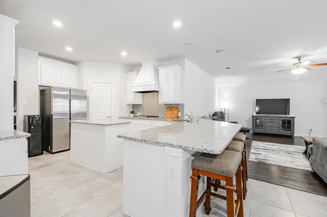 a kitchen with stainless steel appliances granite countertop a sink refrigerator and cabinets