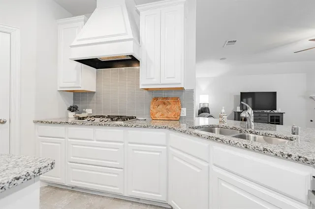 a kitchen with granite countertop white cabinets and white appliances