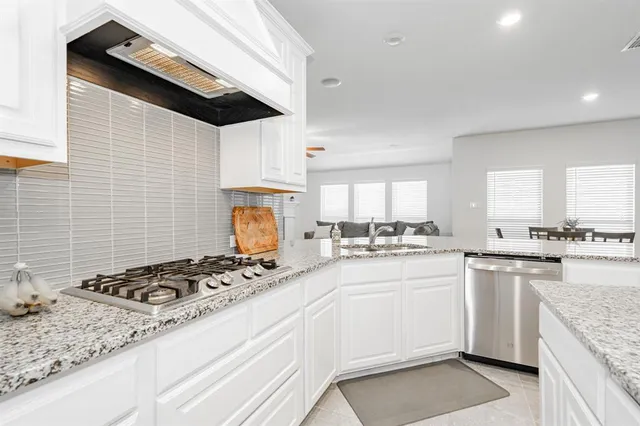 a kitchen with white cabinets and sink
