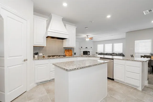 a kitchen with stainless steel appliances granite countertop a stove top oven a sink and dishwasher