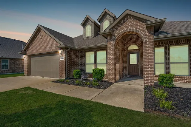 a front view of a house with a garden and plants