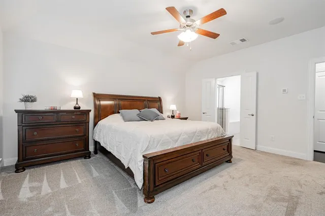 a bedroom with a bed dresser and a large window