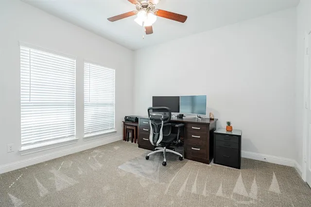 a view of a workspace with furniture and a window
