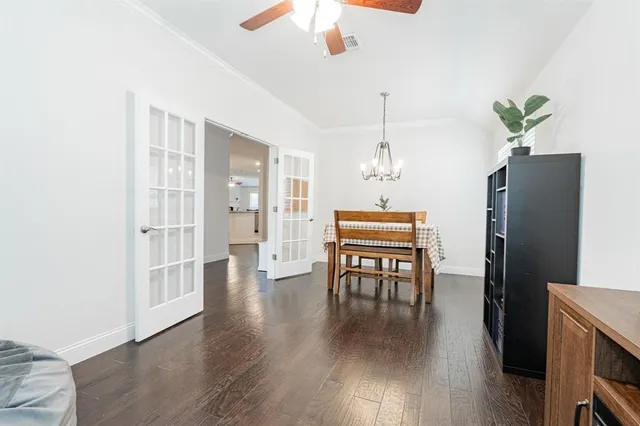 a dining room with furniture a chandelier and wooden floor