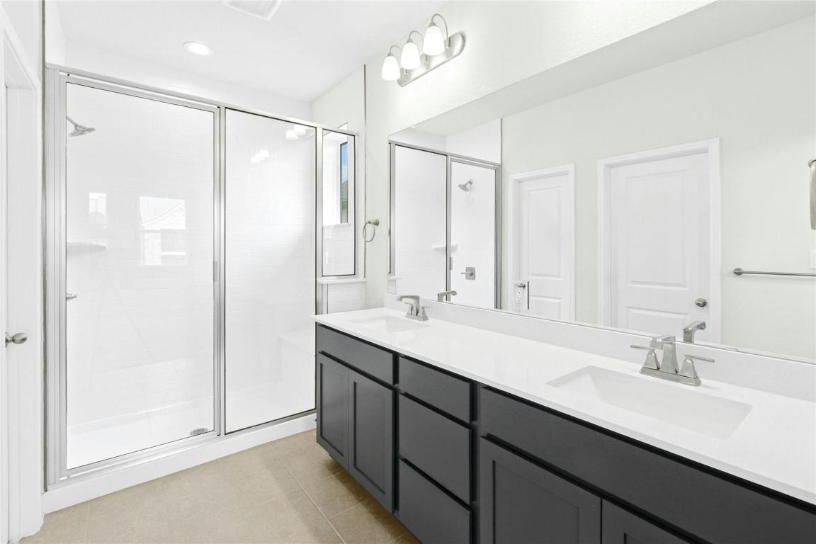320 Creek Road, Unit 302 Dripping Springs, TX 78620 - Photo 8 of 21 Bathroom with a shower stall, double vanity, light tile patterned floors, and recessed lighting
